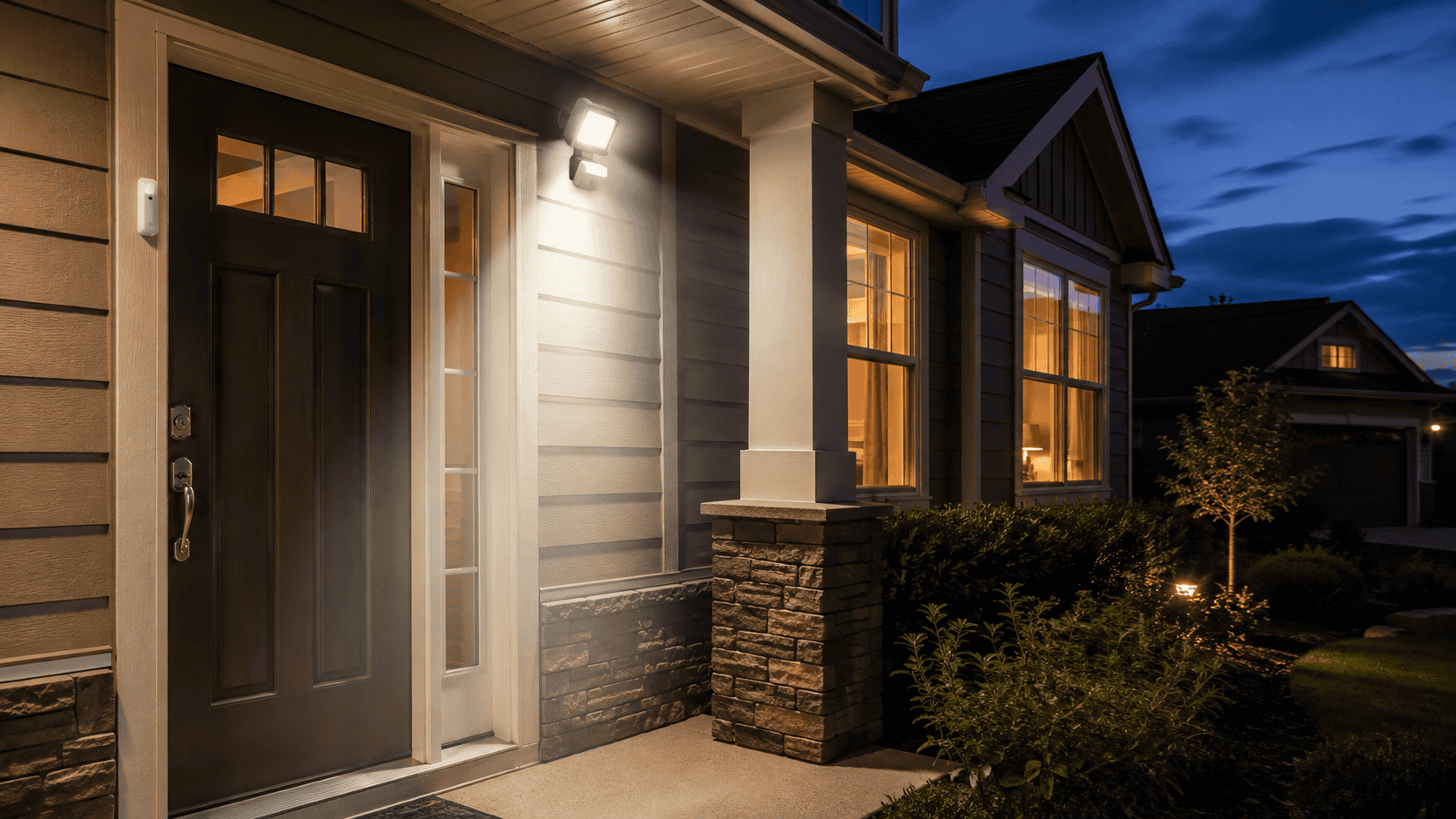Suburban home at dusk with a door mounted security sensor and illuminated motion activated porch light